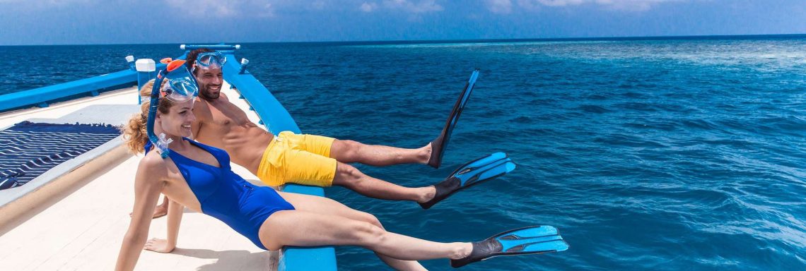 Club Med Villas in FInolhu, Maldives - Photo of a couple on a boat preparing to dive with snorkels