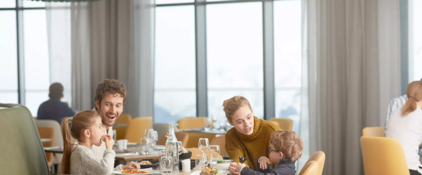 Club Med Arcs Panorama, in France - A family enjoys a meal at the Family Experience restaurant