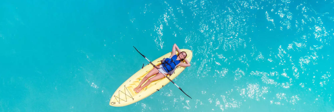 Club Med Columbus Isle, Bahamas - A woman is lying on a kayak in the open sea.