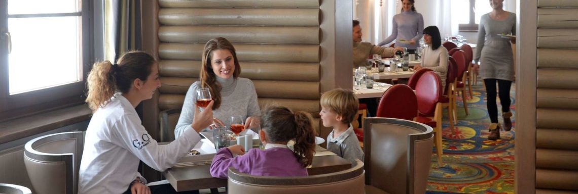 Club Med Pragelato Vialattea, Italy - A family eats around a table for four